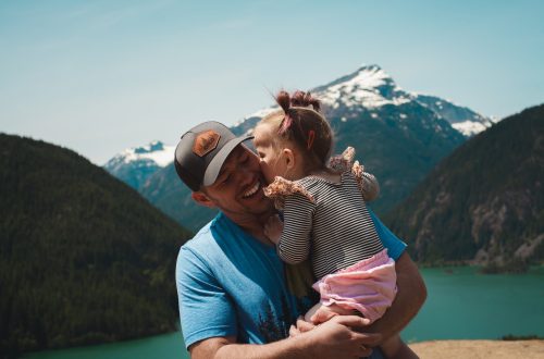 a little girl giving her dad a kiss