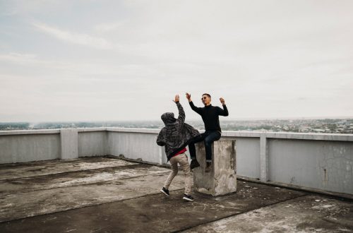 two men going to high five on top of building